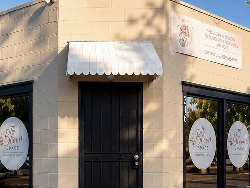 The black entrance door under a scalloped white awning, with the services banner above it
